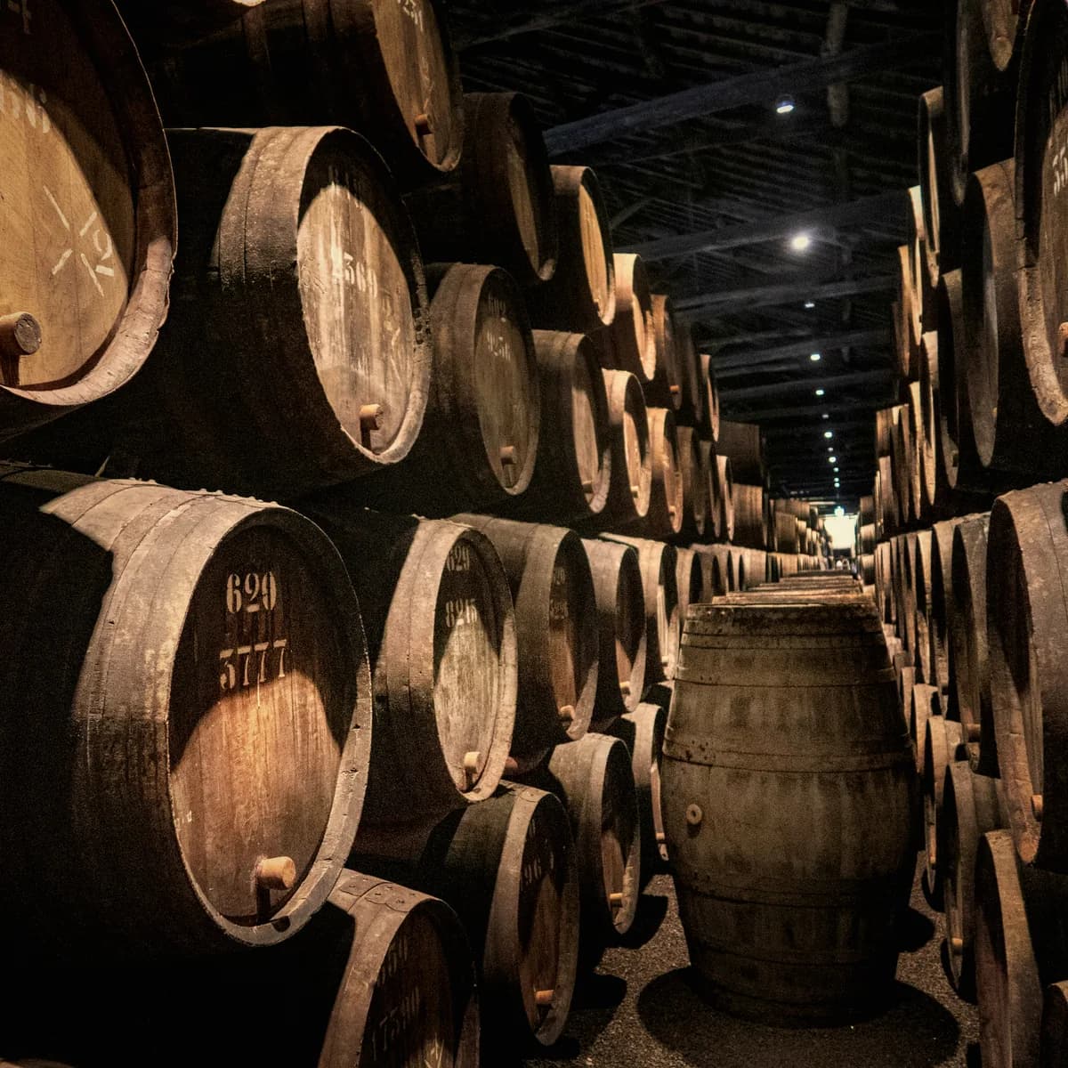 Rows of bourbon barrels aging in a brick rickhouse